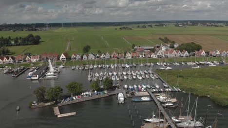 Aerial-backing-up-showing-the-marine-port-area-for-pleasure-boats-and-sailboats-with-typical-houses-of-the-Dutch-village-of-Durgerdam-at-the-Durgerdammerdijk-near-Amsterdam-on-an-overcast-day