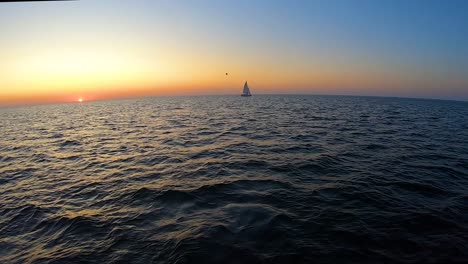 Eine-Yacht-Schwimmt-Im-Zeitraffer-Des-Sonnenuntergangs-Am-Meer