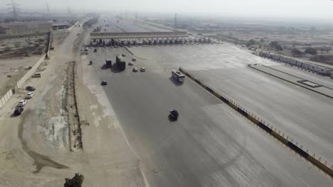 Top-view-of-a-motorway-toll-plaza-of-the-city,-Heavy-vehicles-and-others-entering-and-crossing