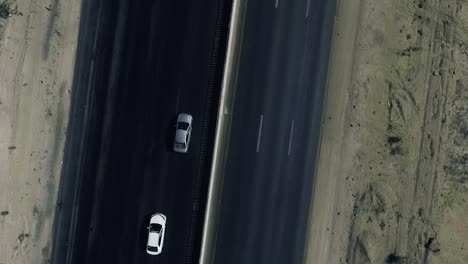 A-slow-mo-aerial-top-view-of-two-cars-moving-on-a-highway-in-northern-areas