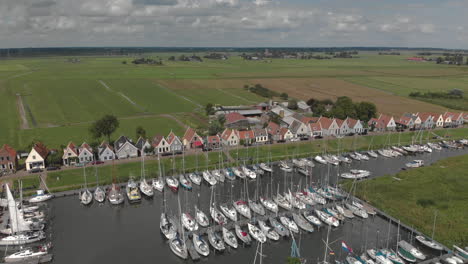 Luftschwenk-Und-Rotation,-Die-Das-Seehafengebiet-Für-Freizeitboote-Mit-Typischen-Häusern-Des-Niederländischen-Dorfes-Durgerdam-Am-Durgerdammerdijk-Bei-Amsterdam-An-Einem-Bewölkten-Tag-Zeigen