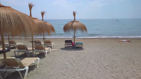 gimbal-shot-POV-walking-towards-water-on-summer-beach-in-marbella,-malaga,-spain,-costa-del-sol-popular-vacation-spot