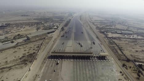 Aerial-view-of-a-motorway-toll-plaza-of-the-city,-Heavy-vehicles-and-others-entering-and-crossing