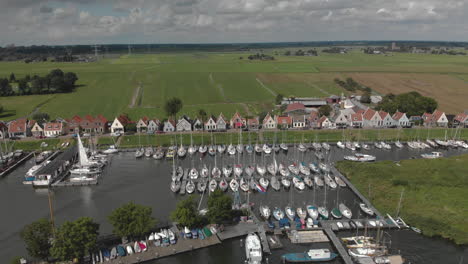 Aerial-backing-up-showing-the-small-village-Durgerdam-near-Amsterdam-with-its-recreational-port-area-with-many-sailboats-docked-against-an-overcast-sky
