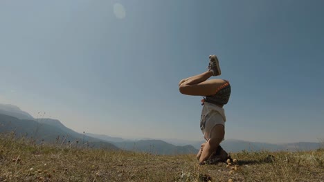 Junges-Athletisches-Mädchen,-Das-Einen-Kurzen-Yoga-Kopfstand-Auf-Einem-Berggipfel-Macht