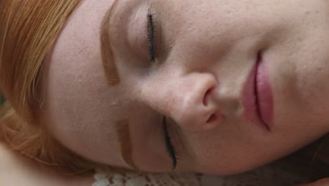 Young-redhead-woman-enjoying-a-peaceful-sleep-in-a-close-up-view-of-her-face