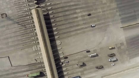 An-aerial-rotational-view-of-a-motorway-toll-plaza-of-the-city,-Heavy-vehicles-and-others-entering-and-crossing