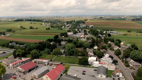 Aerial-trucking-shot-in-Village-of-Intercourse,-Lancaster-County,-PA,-beautiful-green-fields-in-summer