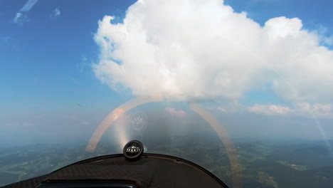 Pilots-POV-from-cockpit-of-small-sport-airplane-flying-cross-country,-compass-with-spinning-propeller,-blue-sky-with-puffy-clouds