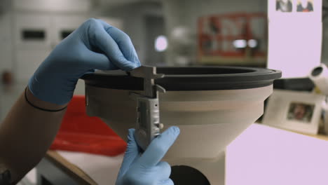 Slider-shot-of-a-technician's-hands-using-a-caliper-to-measure-thickness-of-a-manufacturing-component