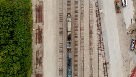 4k-top-down-view-of-train-engine-going-slightly-slower-than-the-camera-while-staying-in-view