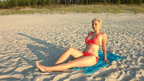 Eine-Sexy-Frau,-Die-Für-Eine-Perfekte-Statische-Fotoposition-Im-Sand-Sitzt