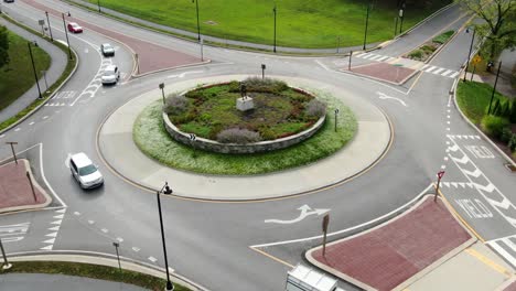 Drone-shot-slow-dolly-forward-and-tilt-down,-aerial-view-of-traffic-circle-roundabout-in-Hershey-Pennsylvania