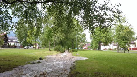 Flooded-water-stream-running-through-a-park-after-heavy-rainfall