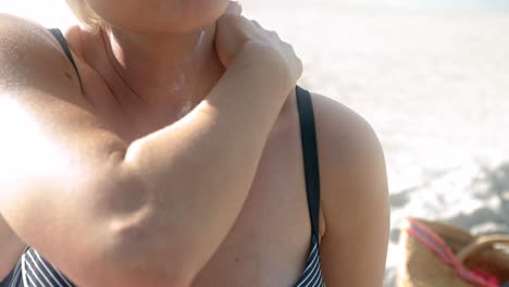 A-young-woman-rubs-her-neck-with-sunscreen