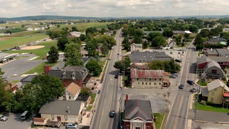 Reverse-aerial-dolly-shot-of-Intercourse,-Lancaster-County,-PA-traffic-and-shops