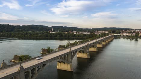 Aerial-hyperlapse-timelapse-of-traffic-crossing-bridge-spanning-Susquehanna-River-between-Wrightsville,-York-County-and-Columbia,-Lancaster-County,-Pennsylvania,-drone-dolly-forward-descending-view