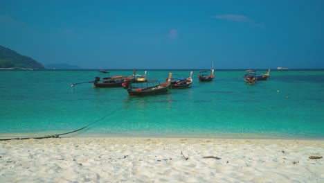 A-beautiful-4K-UHD-Cinemagraph-of-a-tropic-seaside-beach-at-Koh-Lipe,-Thailand-with-traditional-long-tail-boats