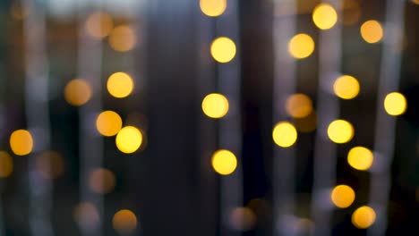 Out-of-focus-strands-of-blinking-yellow-holiday-lights-with-a-blue-background-creating-a-magical-bokeh-effect