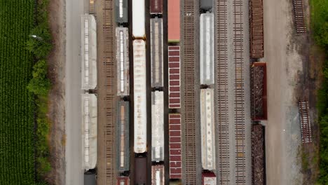 4k-top-down-view-moving-from-top-to-bottom-showing-multiple-trains-while-parked-at-a-train-station