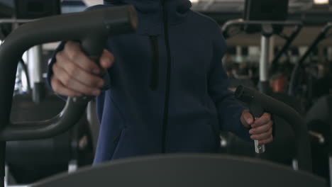 Close-shot-of-man's-hands-while-using-an-elliptical-machine-at-the-gym-stabilized-shot-in-UHD-4K