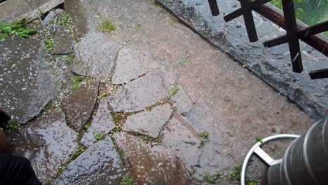 Hail-falling-on-foreground-and-into-puddle,-Slow-motion