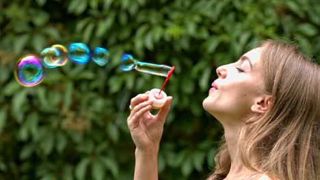 Attraktive-Frau-An-Einem-Sommertag-Im-Park-Spielt,-Indem-Sie-Seifenblasen-Bläst