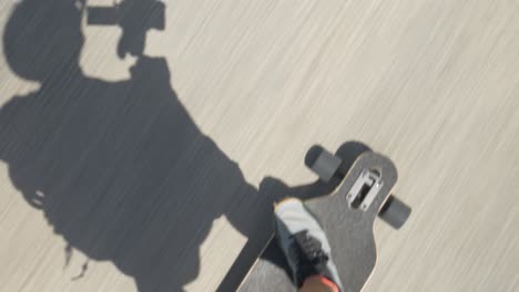 Person,-Die-An-Einem-Sonnigen-Tag-Elektrisches-Skateboard-Auf-Der-Straße-Fährt,-Schatten