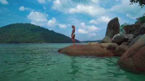 A-beautiful-4K-UHD-Cinemagraph-of-a-tropic-seaside-beach-at-Perhentian-Island,-Malaysia-and-a-brunette-woman-on-the-beach
