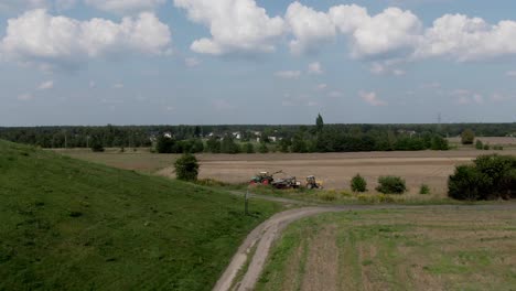 Aerial-Two-Tractors-Working-at-Empty-Field-Next-to-Small-Road-4K