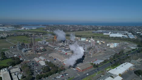 Aerial-Shot-of-Smoke-Stacks-at-Industrial-Plant-Billowing-Smoke-in-Slow-Motion