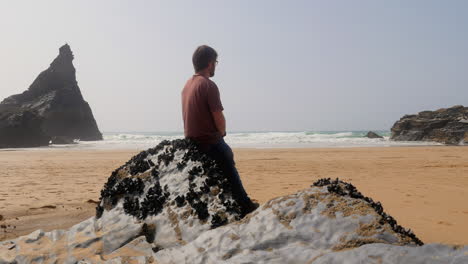 Man-taking-time-out-at-the-beach-lost-in-thought-and-reflecting-on-life,-different-pov