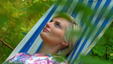 A-woman-relaxing-in-the-sunshine-on-a-sleep-swing-tree-bed-in-nature-with-a-positive-attitude