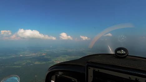 Adventure-of-flying,-pilots-point-of-view-from-the-cockpit-of-light-aircraft,-compas-with-magnetic-windrose-on-dashboard,-freedom-above-the-clouds
