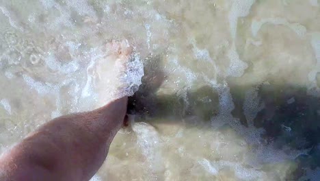 Top-View-Of-Man's-Feet-Walking-On-Sandy-Beach-Barefoot-Splashed-By-Sea-Waves