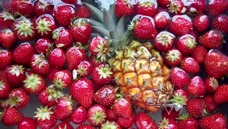 Verkleinern-Sie-Das-Detail-Von-Frischer-Ananas-Und-Erdbeeren,-Die-Im-Wasser-Schwimmen
