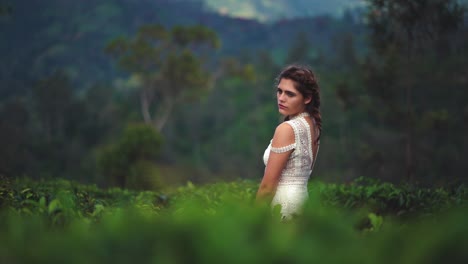 4K-UHD-cinemagraph-of-a-young-pretty-model-in-a-white-dress-is-standing-in-a-tea-plantation-field-in-Sri-Lanka