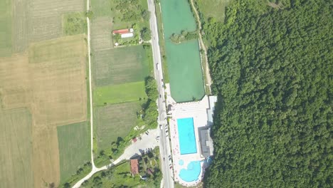 Swimming-pool-near-village,-aerial-view