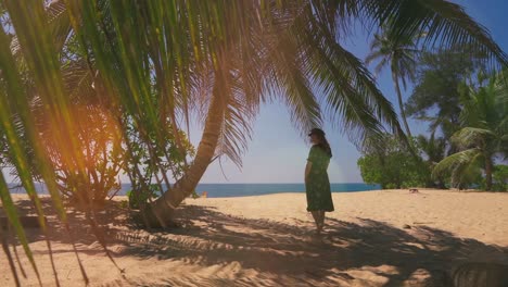 Ein-Wunderschöner-4K-UHD-Cinemagraph-Eines-Tropischen-Küstenstrandes-In-Sri-Lanka-Und-Einer-Jungen-Frau,-Die-Unter-Einer-Palme-Steht