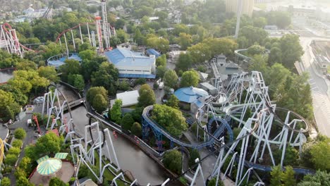 Slow-dolly-forward-drone-shot-revealing-a-maze-of-roller-coasters-and-rides-at-amusement-park