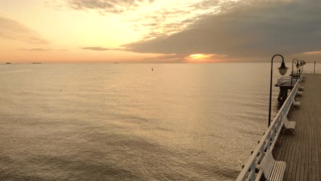 Aerial-footage-from-pier-to-open-sea-during-sunrise