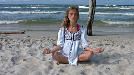 Junge-Schöne-Frau-Trainiert-Den-Atem,-Der-Yoga-Und-Meditation-Am-Meeresstrand-An-Einem-Warmen-Sommersonntag-Praktiziert
