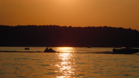 Motorboot-Rast-Bei-Sonnenuntergang-Den-See-Hinunter