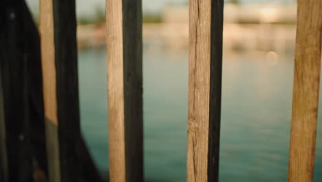 View-through-the-rungs-of-pier-on-wavy-lake