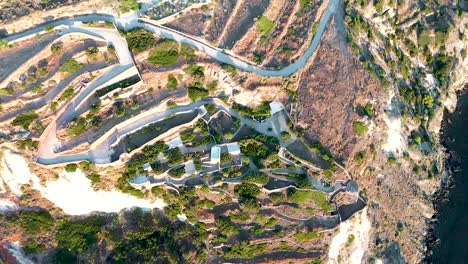Aerial-coastline-shot-with-switchback-road-leading-up-the-mountain