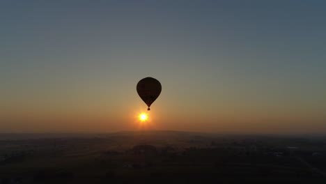 Sonnenaufgang-Eines-Heißluftballons-An-Einem-Nebligen-Morgen-über-Amischem-Ackerland,-Wie-Von-Einer-Drohne-Gesehen