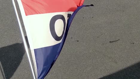 Close-up-view-of-red,-white,-and-blue-OPEN-for-Business-flag-waving-in-summer-breeze