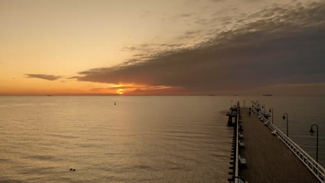 Luftaufnahmen-über-Pier-Und-Bei-Sonnenaufgang-Auf-See-Gehen