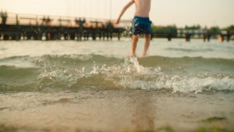 Boy-is-running-and-jumping-into-sunny-summer-lake