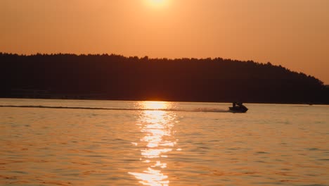 Motor-boat-speeds-down-the-lake-at-sunset